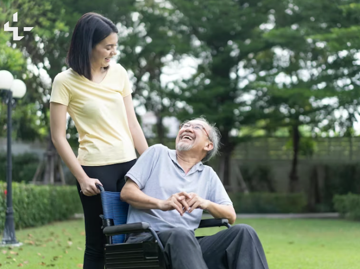 Healthcare worker with an older person laughing together in a sunlit room